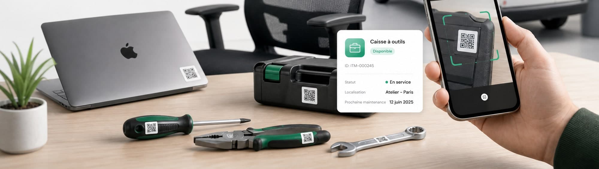 Ordinateur portable, caisse à outils et outillage étiquetés sur un bureau, avec la fiche équipement affichée sur un téléphone.
